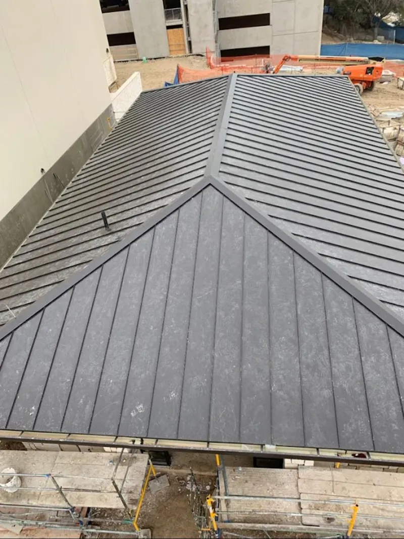 Commercial metal roof construction with crane equipment in Brighton